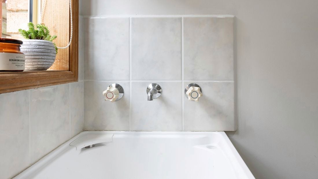 A cleaned bathroom wall with pearly white grout