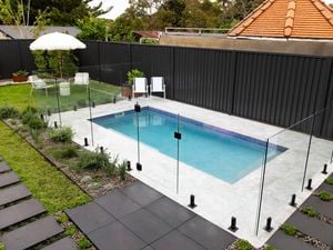 Swimming pool with glass fencing and an inflatable unicorn float.