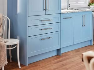 Blue cupboards with chrome handles.
