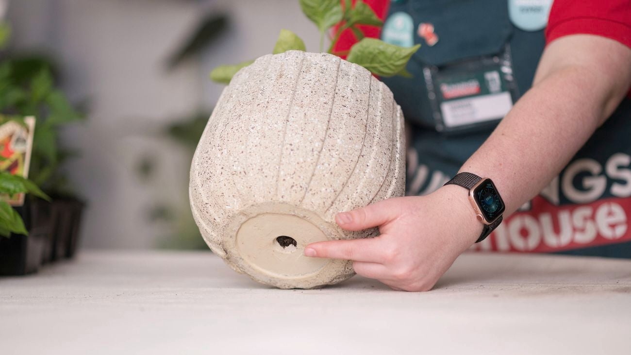 Pointing to a hole in the bottom of a pot.