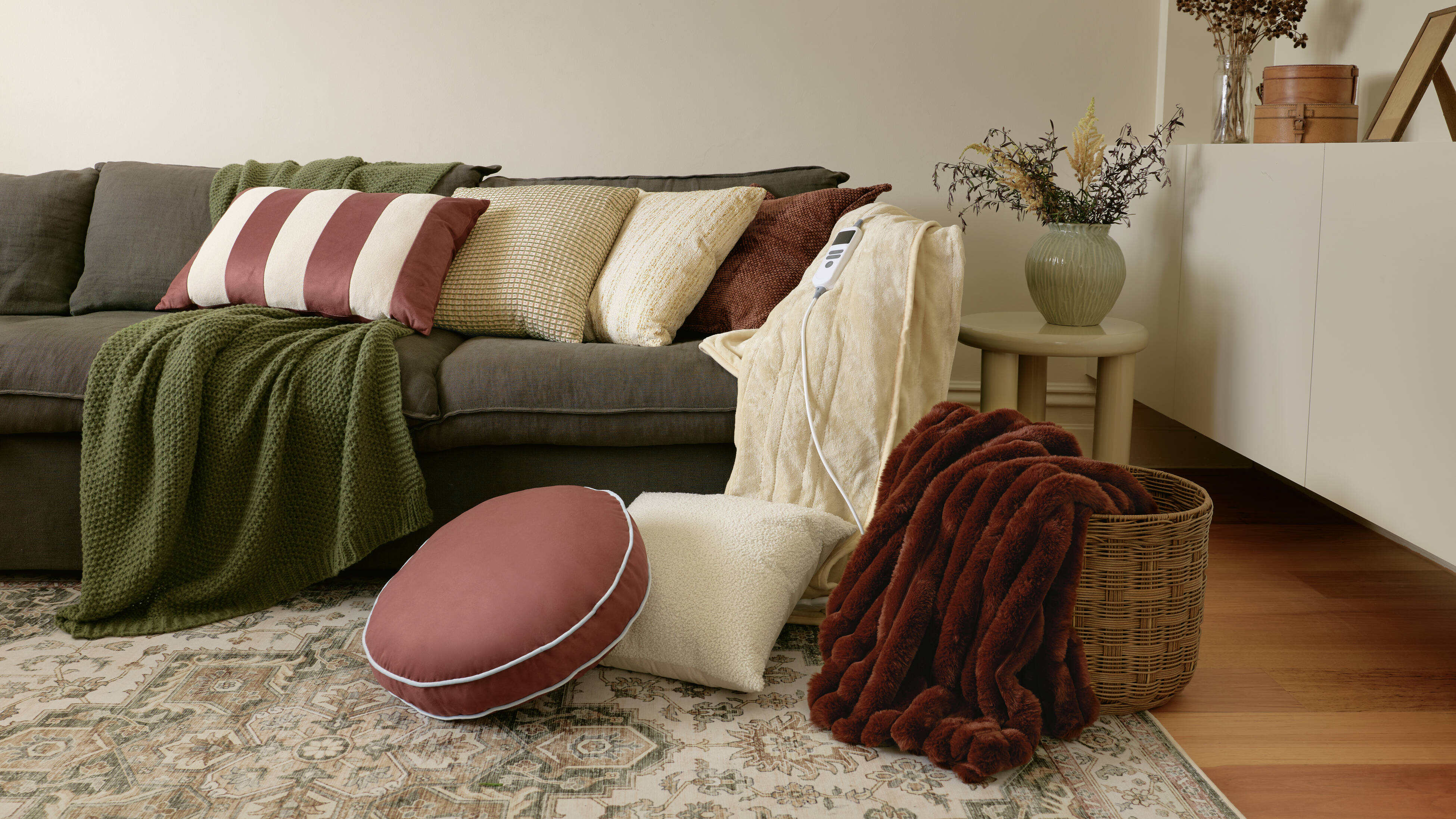 Living room with a sofa styled with cushions, throws, and a patterned rug