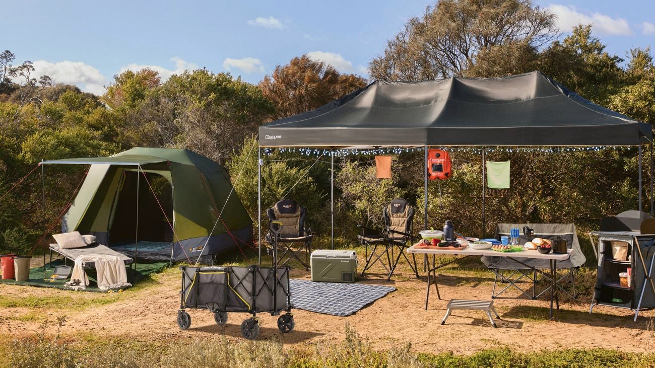 A camp set up with a tent, portable shelter, chairs, food and drinks.