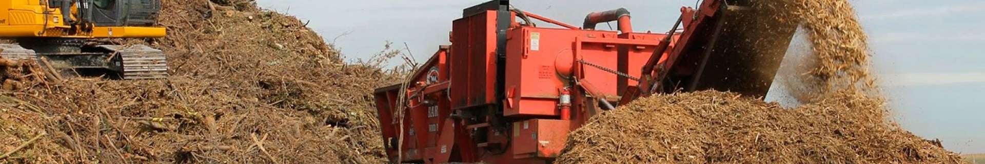 Excavator and mulcher on large piles of mulch