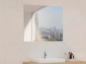 Bathroom with mirror along with wash basin, plant, caddy, slim shelf and white wall tiles.