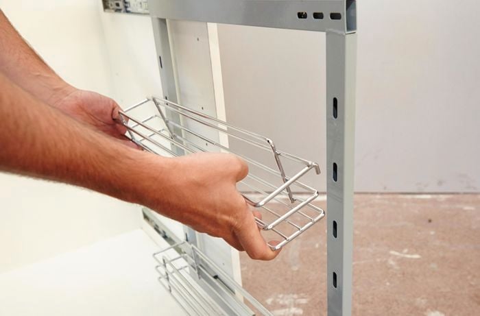 A basket being added to a shelving frame