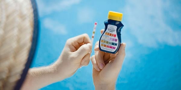 Man holding testing kit for pool 