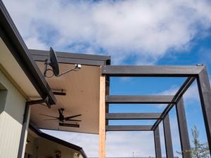 The top of a house with pieces of timber attached to it