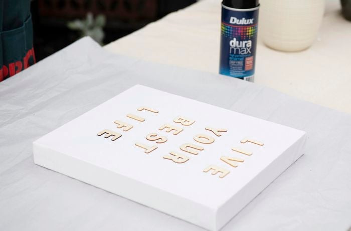The words "Live your best life" spelt out in wooden letters on a stretched canvas