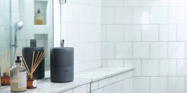 Grey moisture absorber sitting on a bathroom shelf