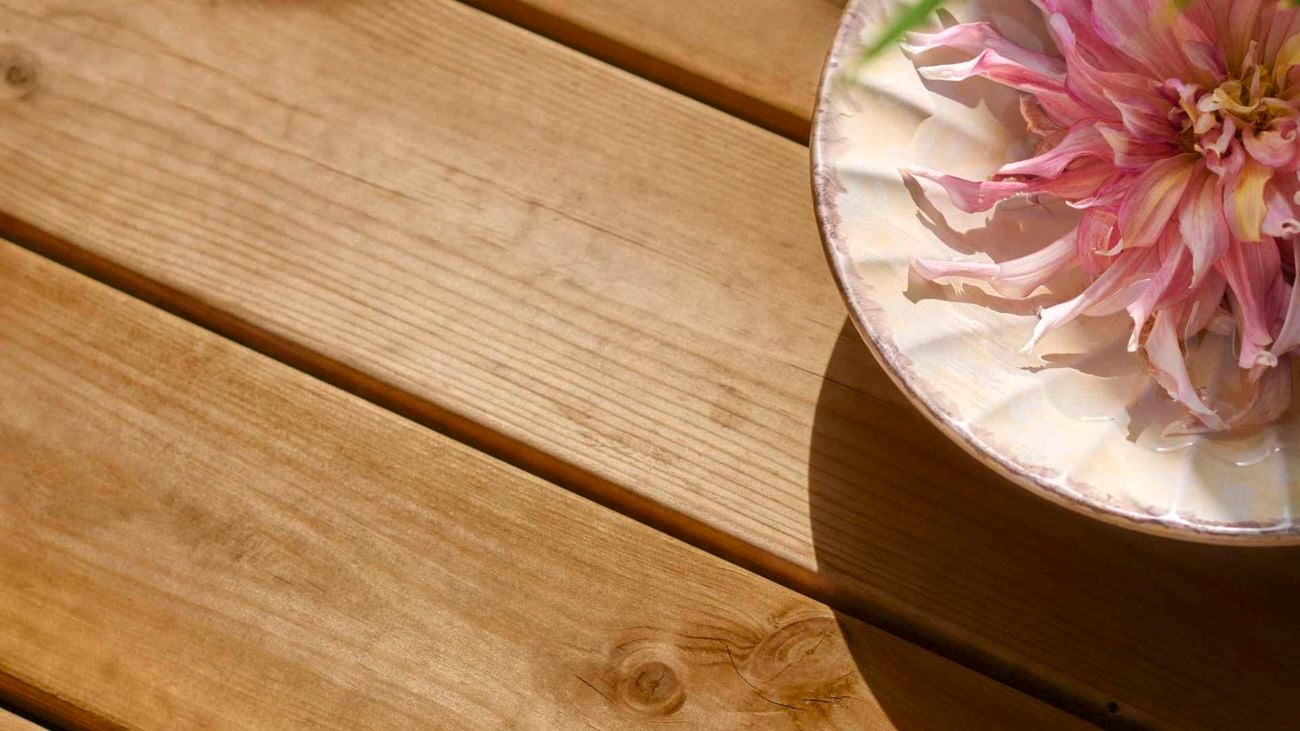 Close up of a timber deck with a flower on top