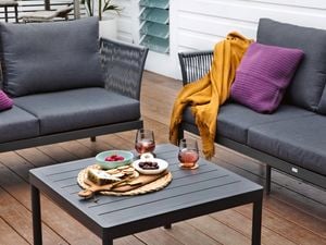Two Mimosa outdoor metal modular lounges with charcoal cushions, and a matching metal coffee table on a deck.