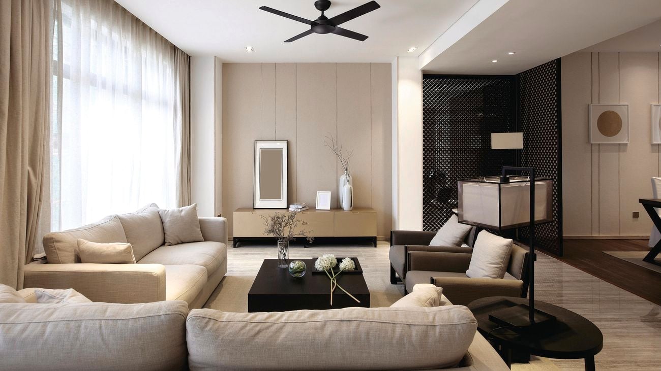 A modern living room in neutral colours with an overhead fan