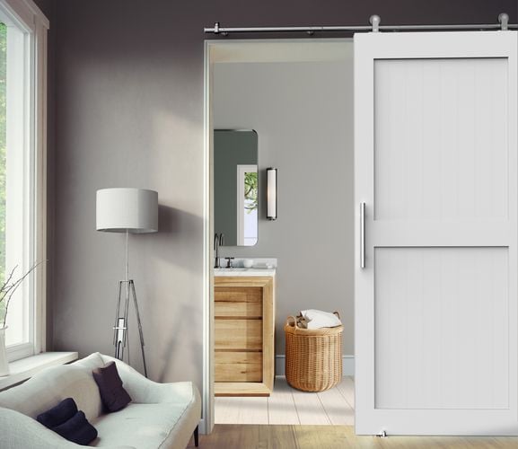 Bathroom interior featuring Rolltrak Stainless Steel Round Top Mount Barn Door Track, Stainless Steel Pull Handle Set and Stainless-Steel Barn Door Guide.