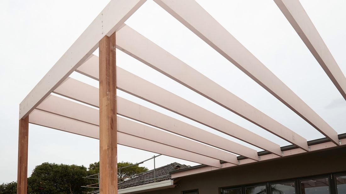 A newly constructed pergola connected to the back of a house