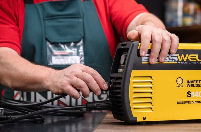 Bunnings team member connecting leads to an arc welder.