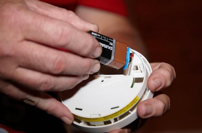 Person replacing the battery in a smoke alarm