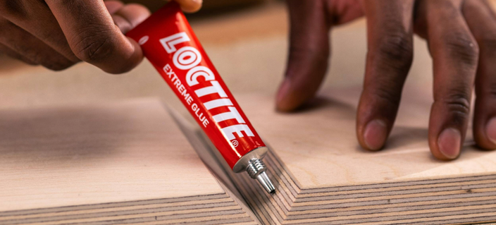 Loctite Extreme Glue being applied to timber panels during a woodworking project.