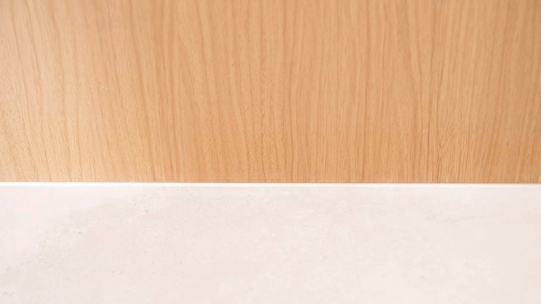 Smooth finished silicone sealant applied along the gap between timber and benchtop.