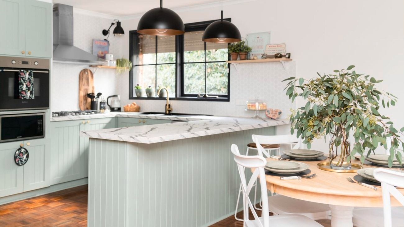 timber kitchen with two large black light pendants hanging over marble bench top