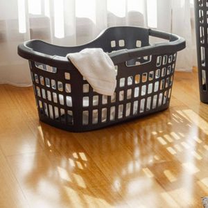 Two laundry baskets placed at the foot of the bed near the window.