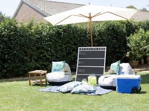 Chalk scoreboard in a backyard leaning on an umbrella
