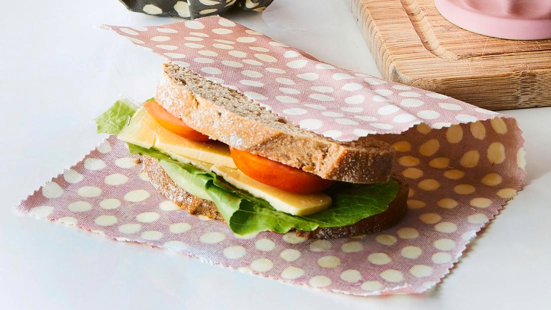 Beeswax wraps on a sandwich, apple and bowl.