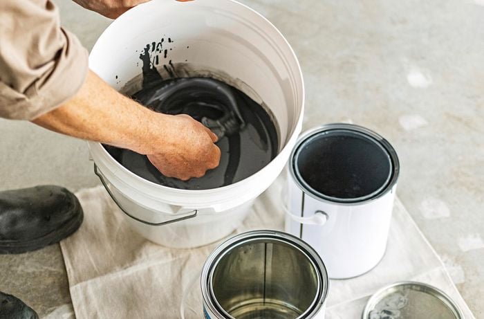 A person mixing Dy-Mark epoxy in a bucket