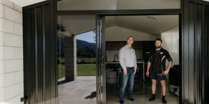 Two people standing in the door way at the back of a house