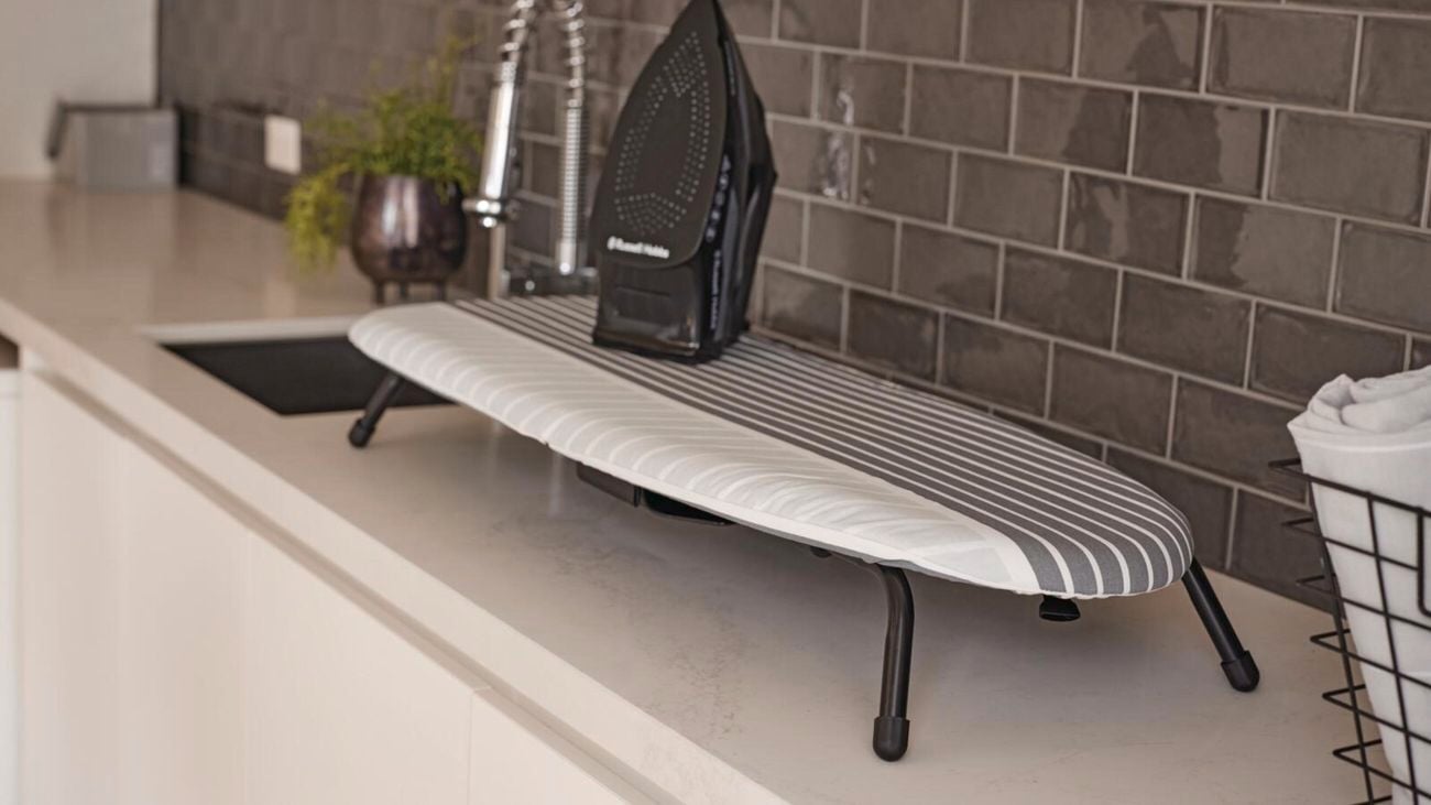 A small, ironing board sits on top of a bench