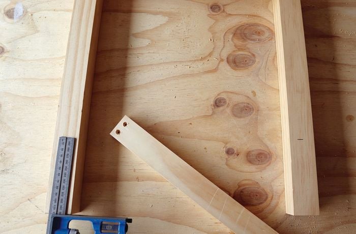 Person assembling timber frame of bench