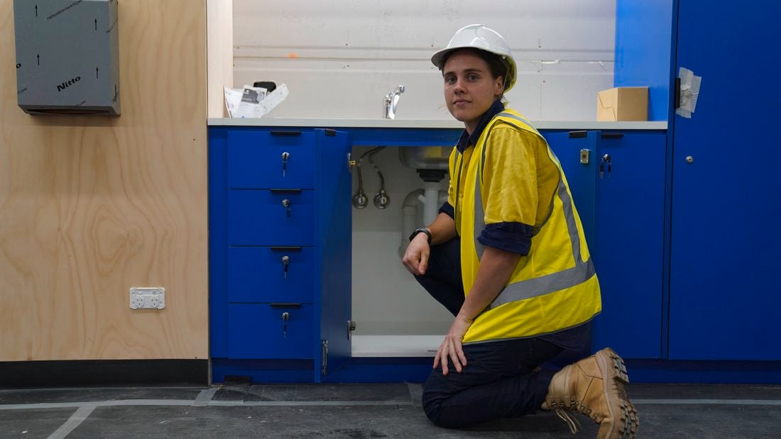 AFLW star Jasmine Garner in a hi-vis shirt while training as an apprentice plumber