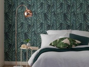 Forrest green leafy wallpaper in a bedroom.
