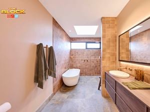 Natural coloured brown bathroom with timber vanity with towel rails and bath