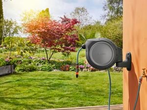 Gardena hose reel attached to wall in garden