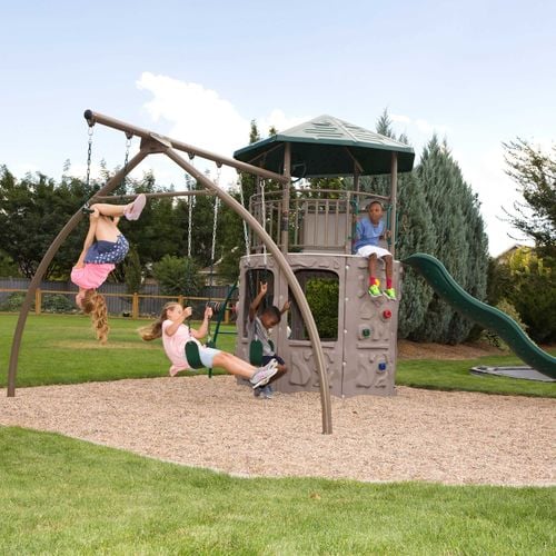 kids swinging on swings and using a playground