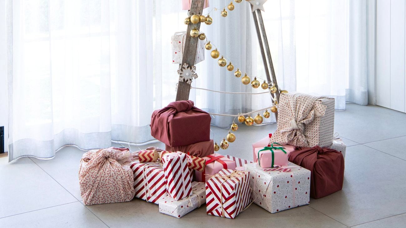 Timber ladder covered with tinsel, surrounded by gifts.
