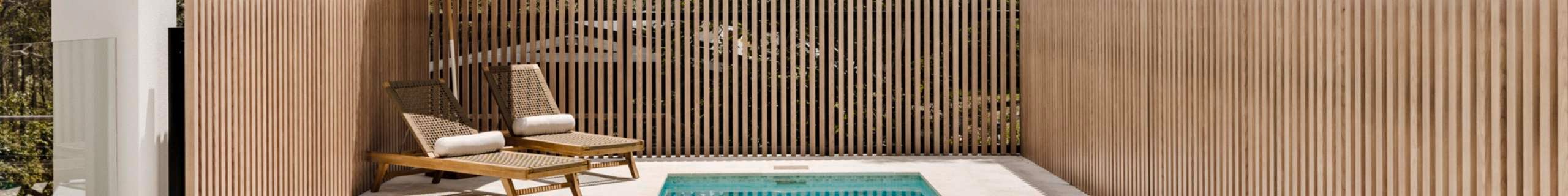 Fenced in pool area with sunlounge and umbrella.