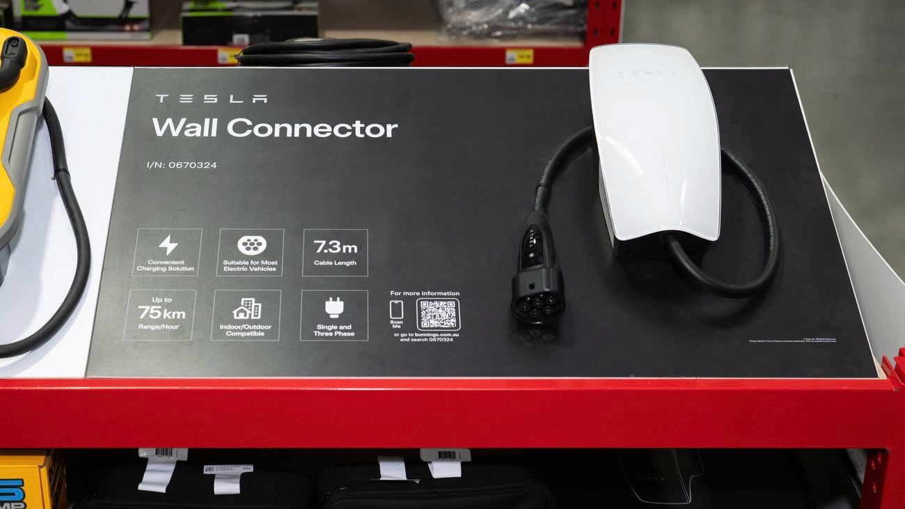 A Tesla Wall Connector on display, showcasing its 7.3m cable, EV compatibility, dual-phase support, and 75 km/hour charging range. 