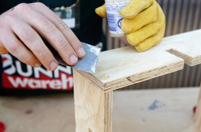 Person filling holes in timber with putty