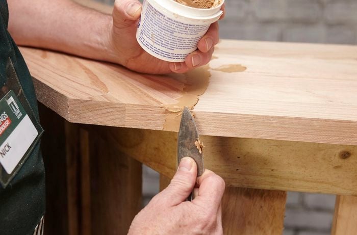 Putty being used to fill the joints in a wooden pallet wine bar