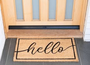 Front door with a doormat featuring the word "Hello".