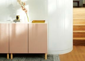 White buffet unit with dusty pink doors against a white wall