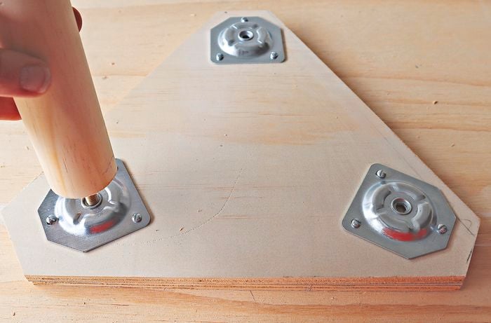 Person screwing table leg into tabletop