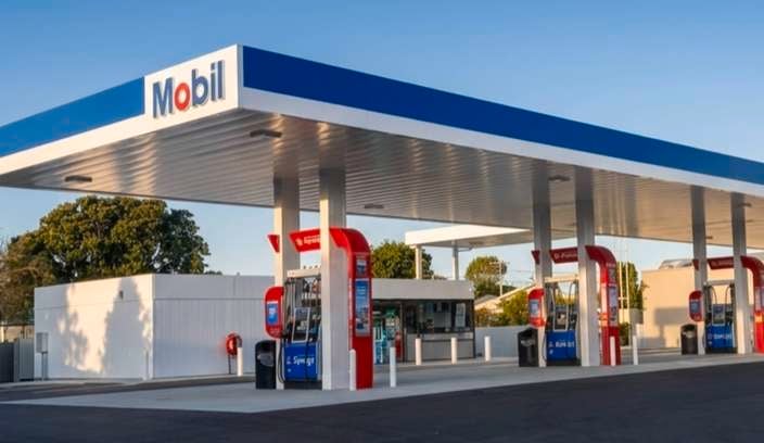 Modern Mobil petrol station with multiple fuel pumps under a large blue and white canopy.