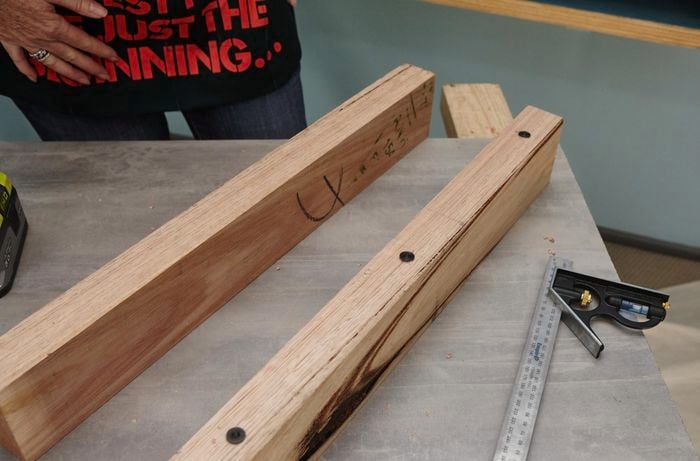 Two lengths of timber, one with holes and dowel markers