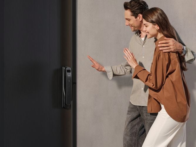 Couple standing in front of a door with a Philips Smart Lock installed