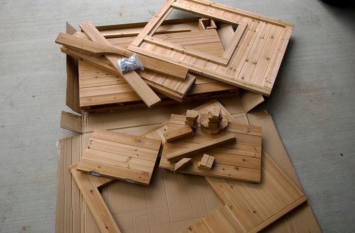 A pile of unassembled wood parts for building a cubby house