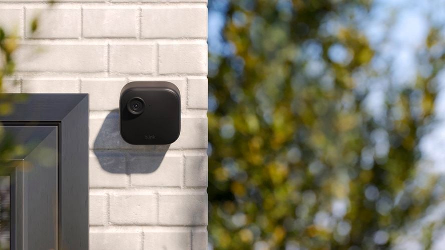Smart camera on brick wall outside.
