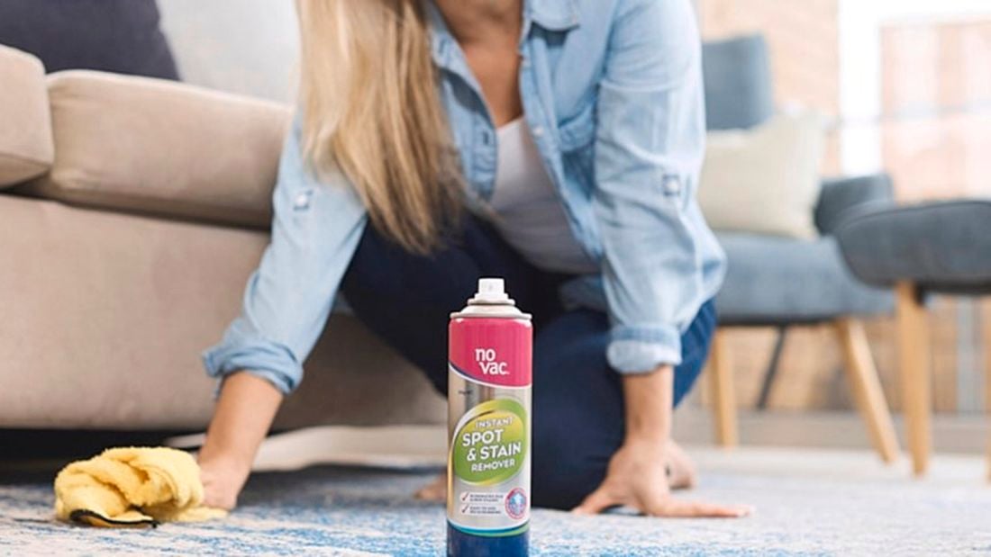 Person cleaning carpet with No Vac product and cloth.