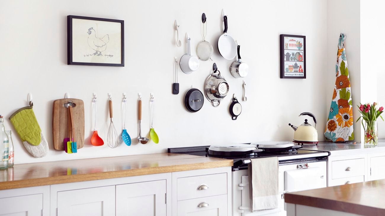 Kitchen pans and utensils hung above a benchtop with Command™adhesive hooks